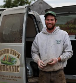 Farmer Kev’s Organic A farmer smiles near a truck door