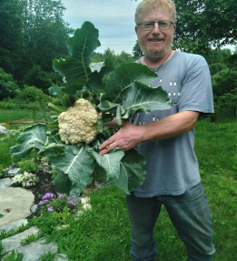 JP 2025_Avalon Acres Michael Levine A farmer smiles holding a head of cauliflower